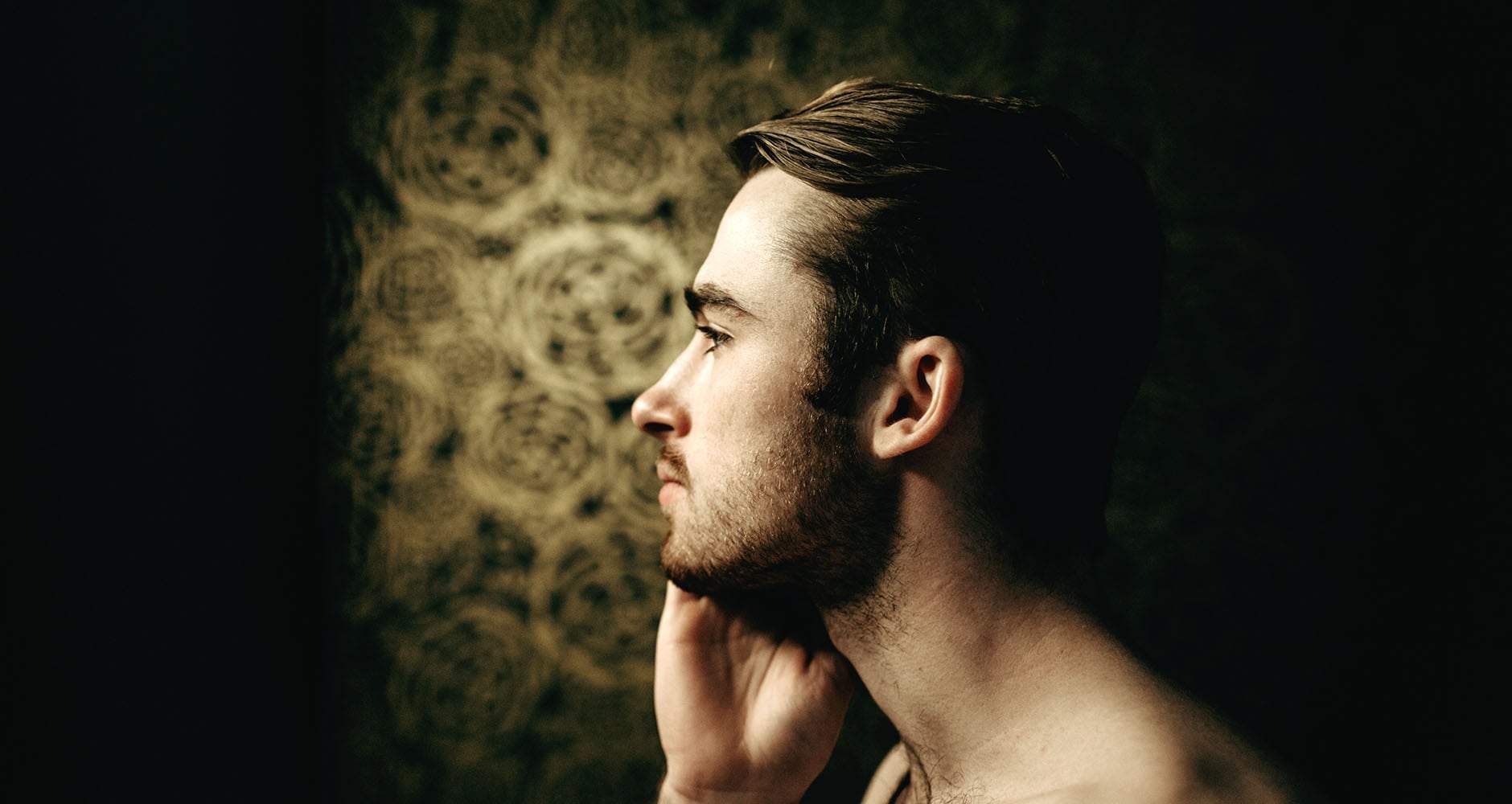 A man using our Cure-A system on his face in his bathroom that was created with ingredients that clear up his acne.