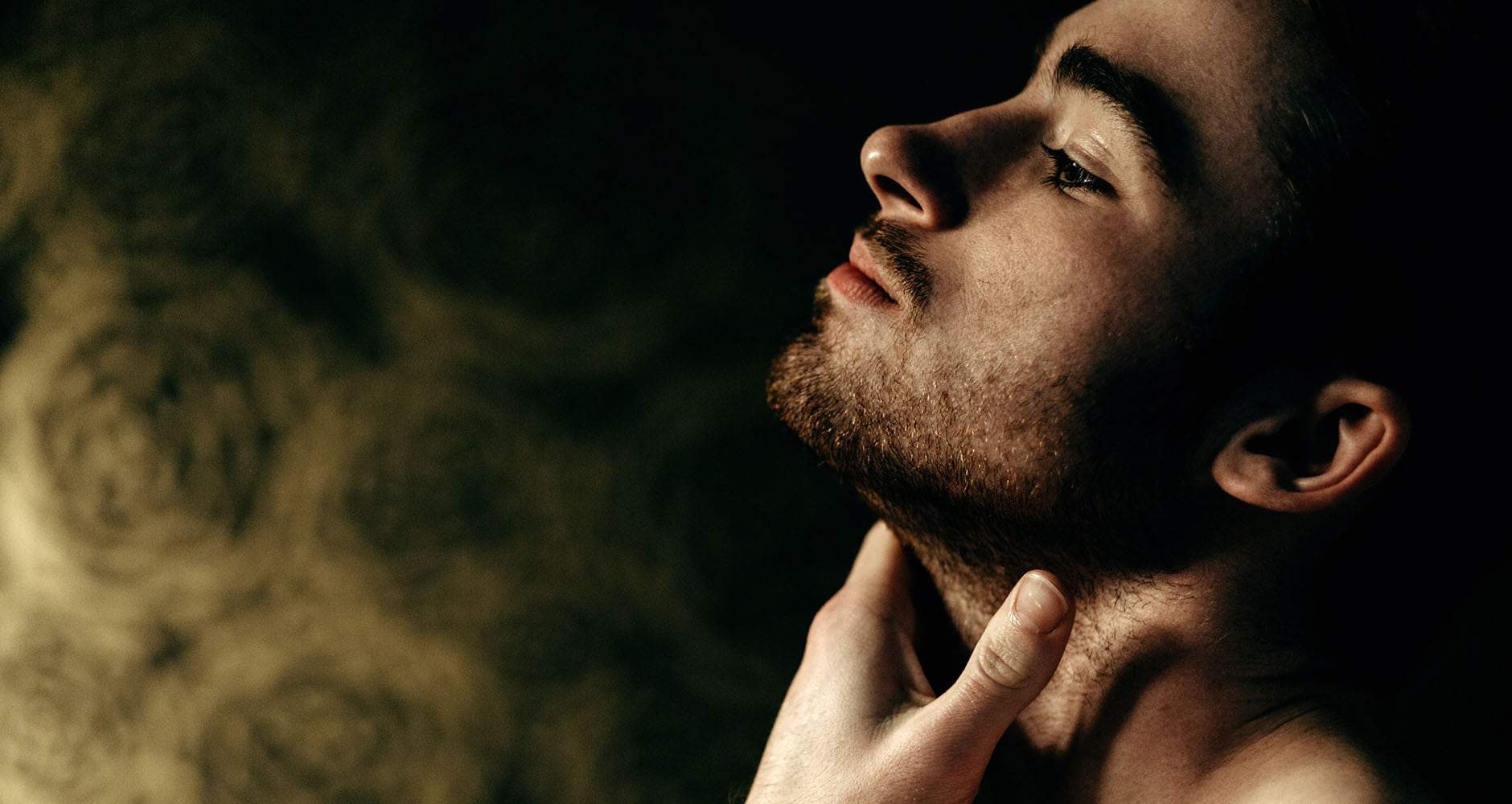 A man using our face solution for men in his bathroom to tame his beard, clean, freshen, moisturize, and hydrate his skin.